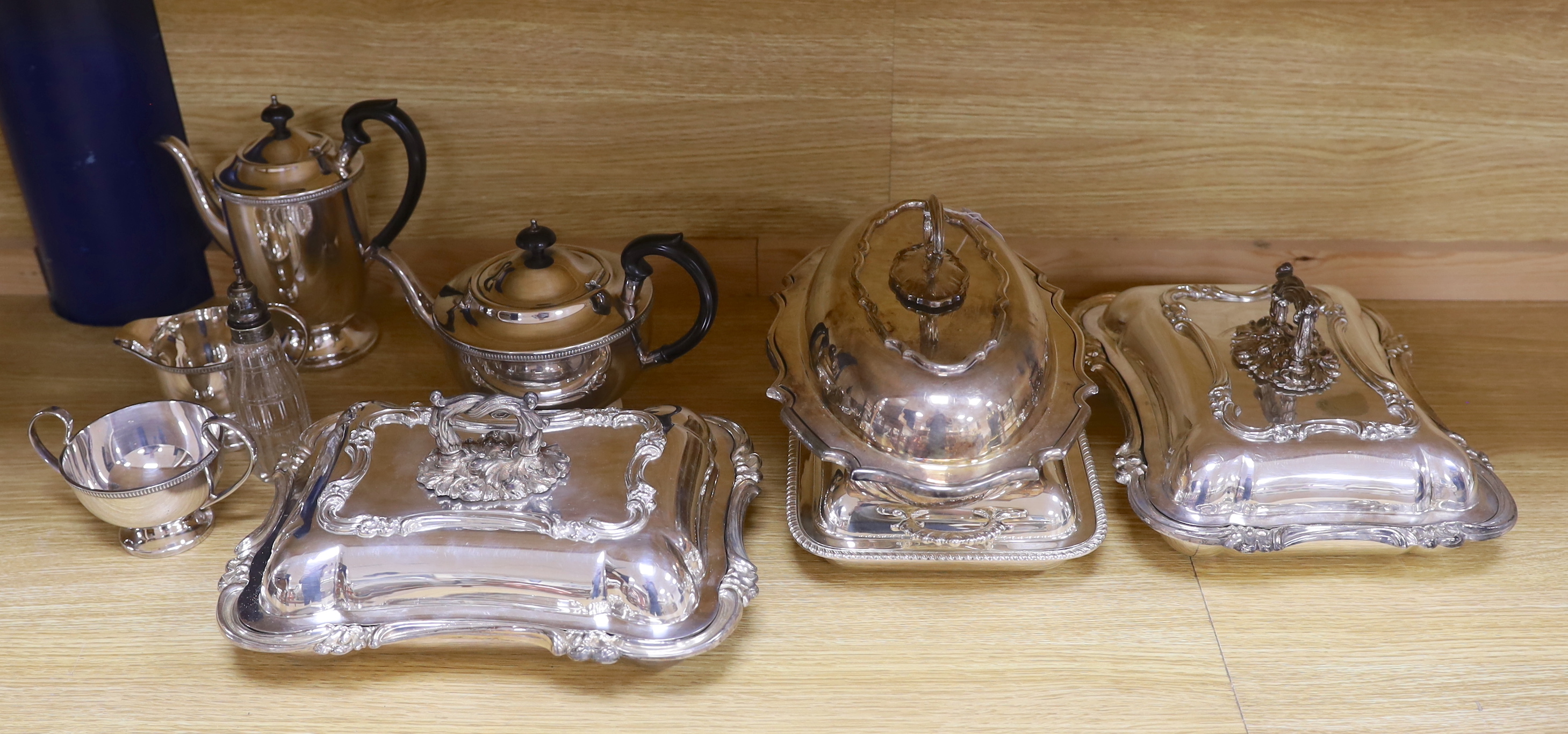 A quantity of silver plate including tea and coffee pots with ebonised handles and a pair of serving dishes